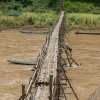 Wooden_footbridge_in_Luang_Prabang_with_a_worker_busy_at_its_consolidation.jpg